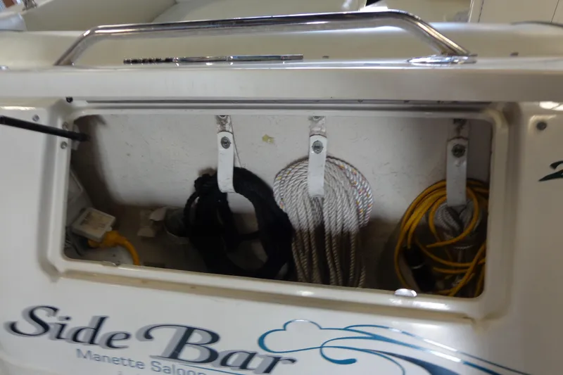 Slide: The Image of 2000 Sea Ray 240 Sundancer storage compartment with ropes and cables. - 30