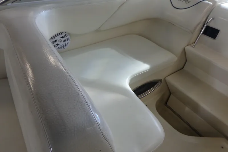 Slide: The Image of Interior seating of a 2000 Sea Ray 240 Sundancer boat, featuring white upholstery. - 9