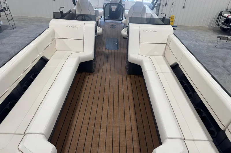 Slide: The Image of 2025 Manitou 26 Explore boat interior with white seating and wood flooring. - 17