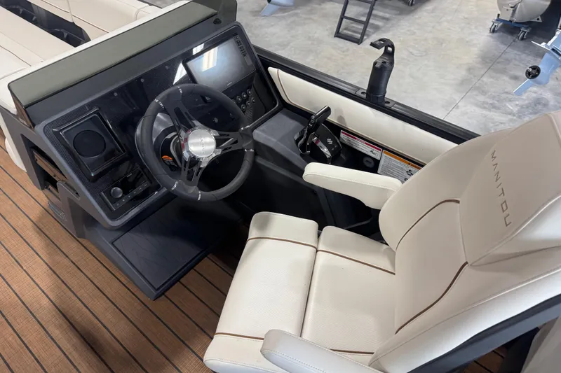 Slide: The Image of Interior of 2025 Manitou 26 Explore boat, featuring steering wheel and luxurious seating. - 23