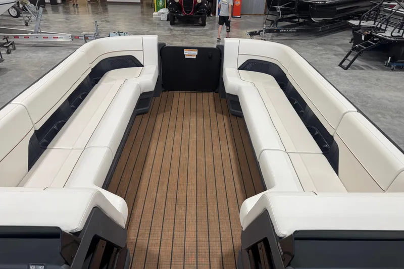 Slide: The Image of 2025 Manitou 26 Explore boat interior with spacious seating and wood-style flooring. - 24