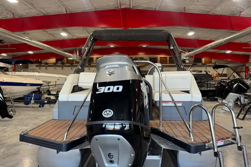 Slide: The Image of 2025 Manitou 26 Explore boat with Suzuki 300 engine in showroom. - 6