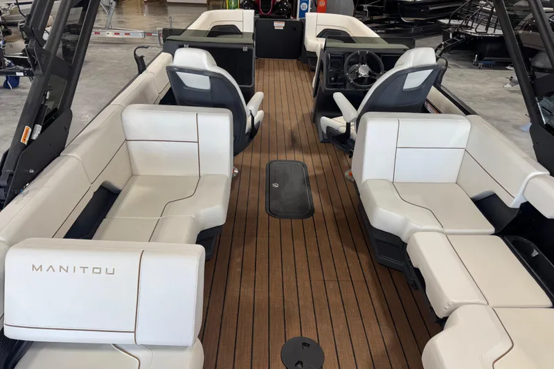Slide: The Image of Interior of 2025 Manitou 26 Explore boat with white seating and wood flooring. - 7