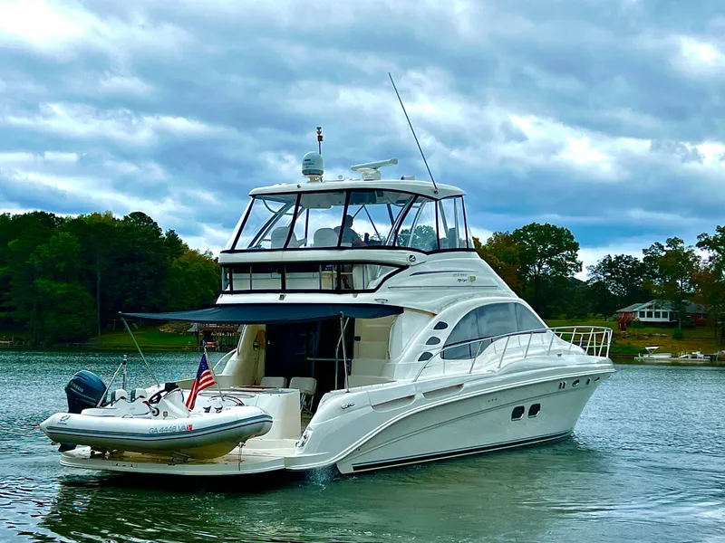 Slide: The Image of 2009 Sea Ray 58 Sedan Bridge yacht cruising on a scenic lake. - 2