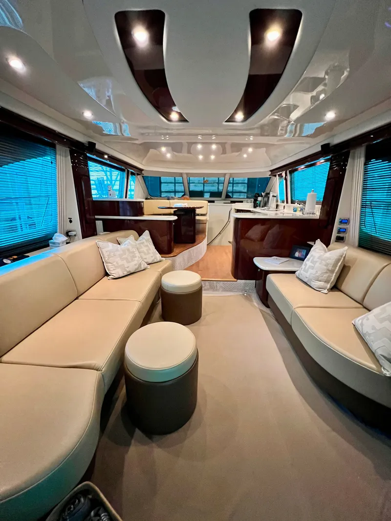 Slide: The Image of 2009 Sea Ray 58 Sedan Bridge yacht cruising on a scenic lake with forested shoreline. - 4