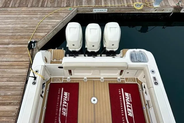 Slide: The Image of Boston Whaler 345 Conquest Pilothouse 2021 docked, featuring triple outboard engines. - 10