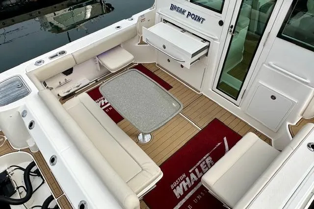 Slide: The Image of 2021 Boston Whaler 345 Conquest Pilothouse interior with seating and table. - 12