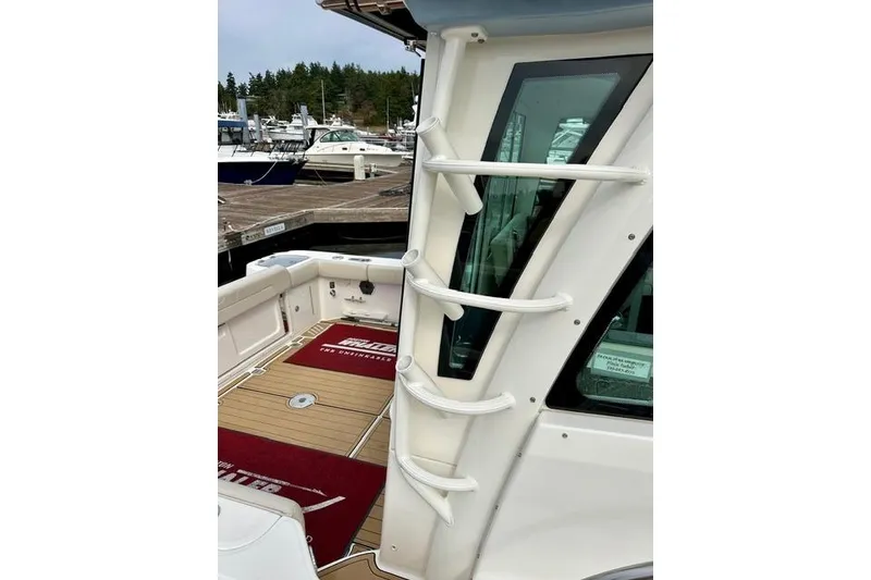 Slide: The Image of 2021 Boston Whaler 345 Conquest Pilothouse docked, showcasing sleek design and spacious deck. - 13
