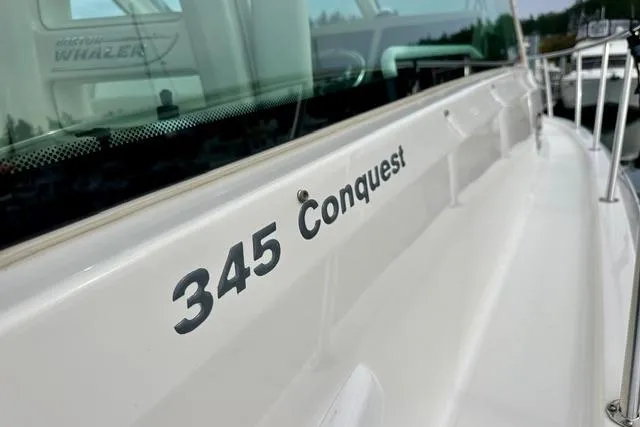 Slide: The Image of 2021 Boston Whaler 345 Conquest Pilothouse boat, side view with model name visible. - 15