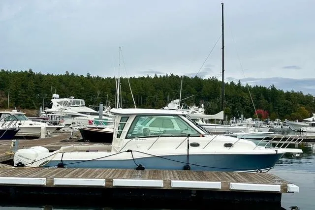 Slide: The Image of 2021 Boston Whaler 345 Conquest Pilothouse docked in a marina with surrounding boats. - 2