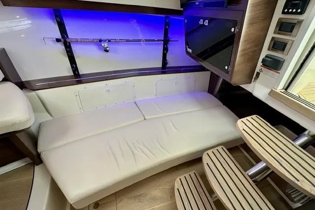 Slide: The Image of 2021 Boston Whaler 345 Conquest Pilothouse interior with seating, rod holder, and ambient lighting. - 26