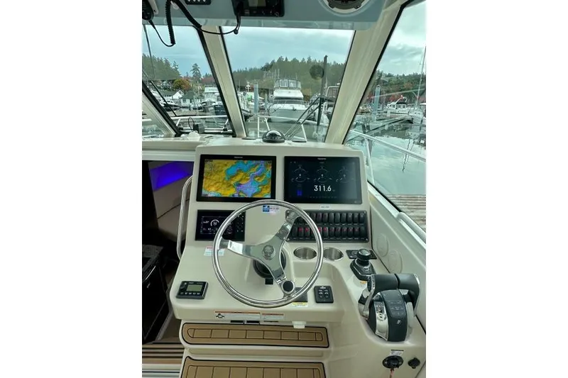 Slide: The Image of 2021 Boston Whaler 345 Conquest Pilothouse helm with navigation screens and controls. - 38