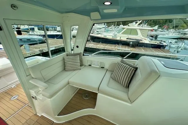 Slide: The Image of 2021 Boston Whaler 345 Conquest Pilothouse interior with cushioned seating and marina view. - 41