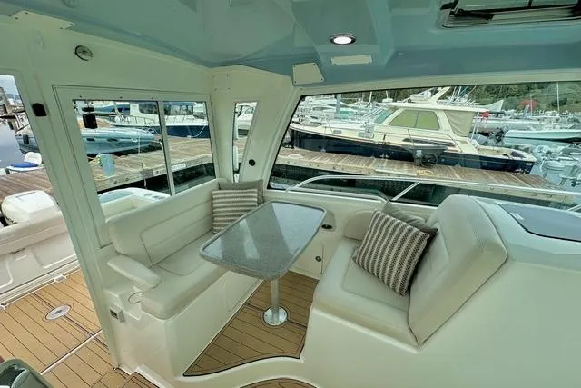 Slide: The Image of Interior of 2021 Boston Whaler 345 Conquest Pilothouse with seating and table, docked at marina. - 42