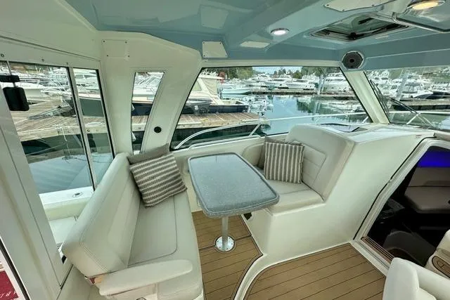 Slide: The Image of Interior of 2021 Boston Whaler 345 Conquest Pilothouse with seating and table, docked at marina. - 43