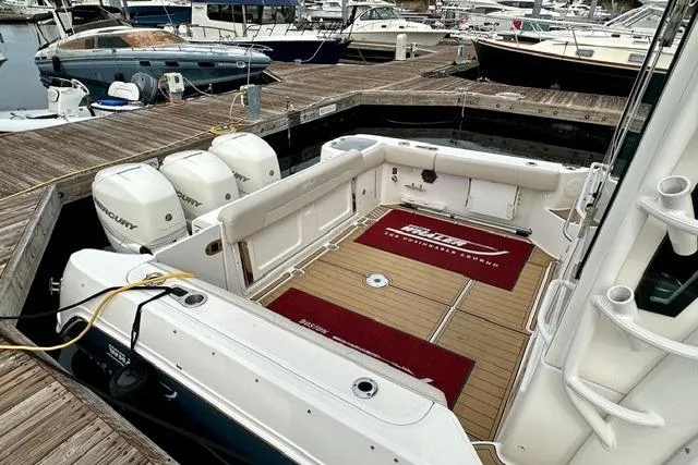 Slide: The Image of 2021 Boston Whaler 345 Conquest Pilothouse docked, showcasing spacious deck and triple outboard engines. - 45