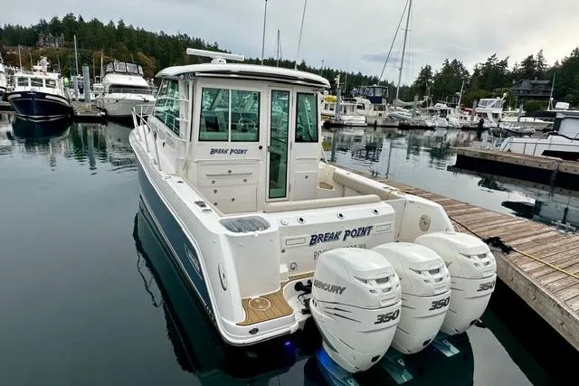 Slide: The Image of 2021 Boston Whaler 345 Conquest Pilothouse docked with triple Mercury 350 engines. - 47