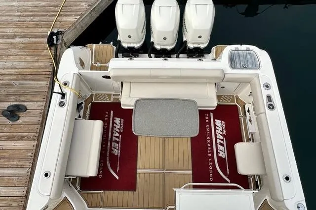 Slide: The Image of 2021 Boston Whaler 345 Conquest Pilothouse with triple engines, docked, featuring spacious deck area. - 5