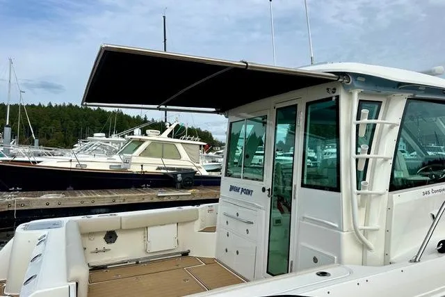 Slide: The Image of 2021 Boston Whaler 345 Conquest Pilothouse docked, featuring spacious deck and pilothouse. - 6
