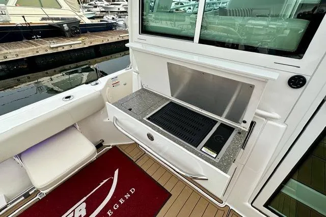 Slide: The Image of Boston Whaler 345 Conquest Pilothouse 2021 with outdoor grill and seating at marina. - 7