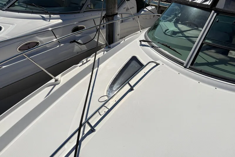 Slide: The Image of Interior of 2012 Sea Ray 370 Sundancer with beige seating, TV, and wooden cabinetry. - 41