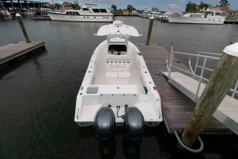 Slide: The Image of 2017 Sea Hunt Gamefish 27 Coffin Box docked at marina, featuring dual engines. - 2
