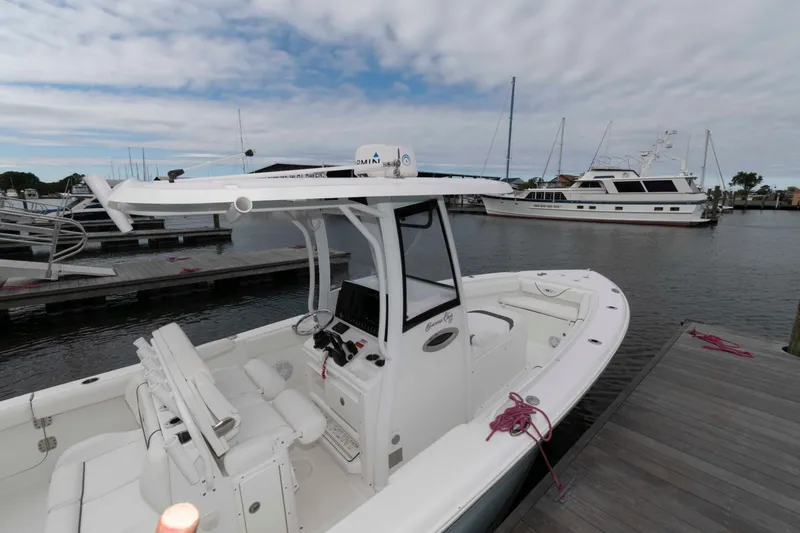 Slide: The Image of 2017 Sea Hunt Gamefish 27 Coffin Box boat docked at marina, featuring spacious deck and helm. - 3