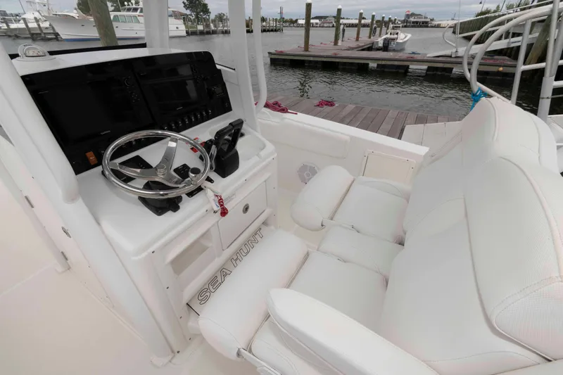 Slide: The Image of 2017 Sea Hunt Gamefish 27 Coffin Box boat interior with steering wheel and seating. - 6