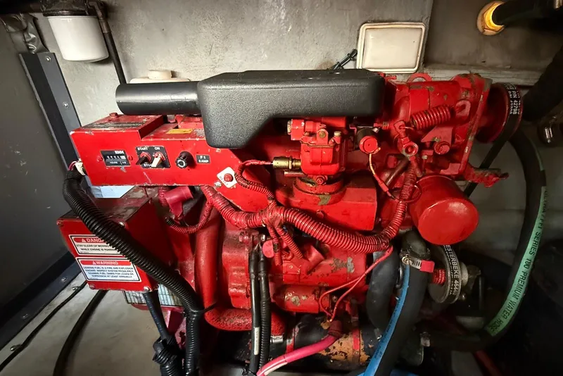Slide: The Image of Engine compartment of a 2000 Sea Ray 380 Sundancer, featuring red mechanical components. - 25