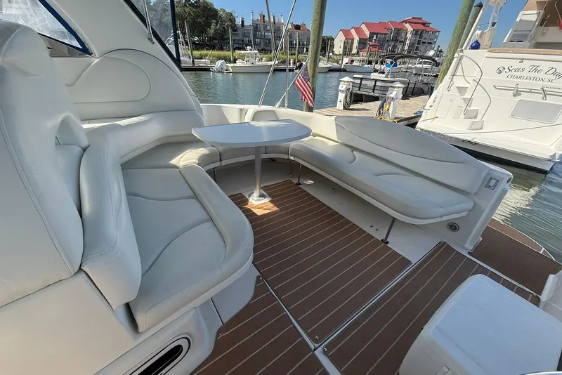 Slide: The Image of 2000 Sea Ray 380 Sundancer yacht interior with white seating and table in marina. - 5