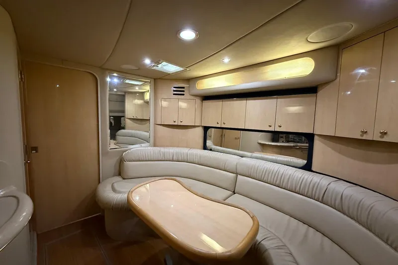 Slide: The Image of Luxurious interior of a 2000 Sea Ray 380 Sundancer yacht with plush seating and wooden cabinetry. - 6