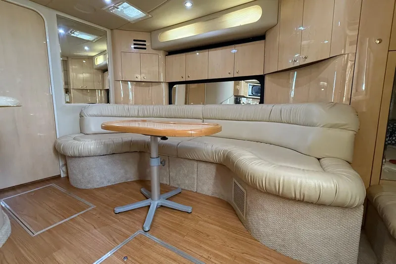 Slide: The Image of Luxurious interior of 2000 Sea Ray 380 Sundancer yacht with curved seating and wooden table. - 7