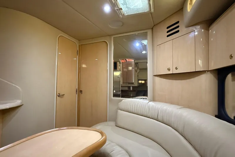 Slide: The Image of Interior of 2000 Sea Ray 380 Sundancer yacht with beige leather seating and wooden cabinetry. - 8