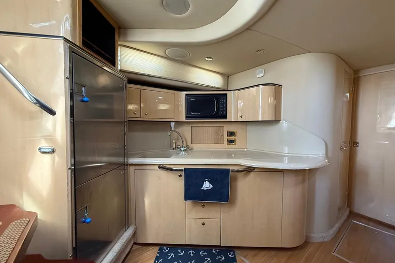 Slide: The Image of Interior of 2000 Sea Ray 380 Sundancer yacht, featuring a modern kitchen area. - 9