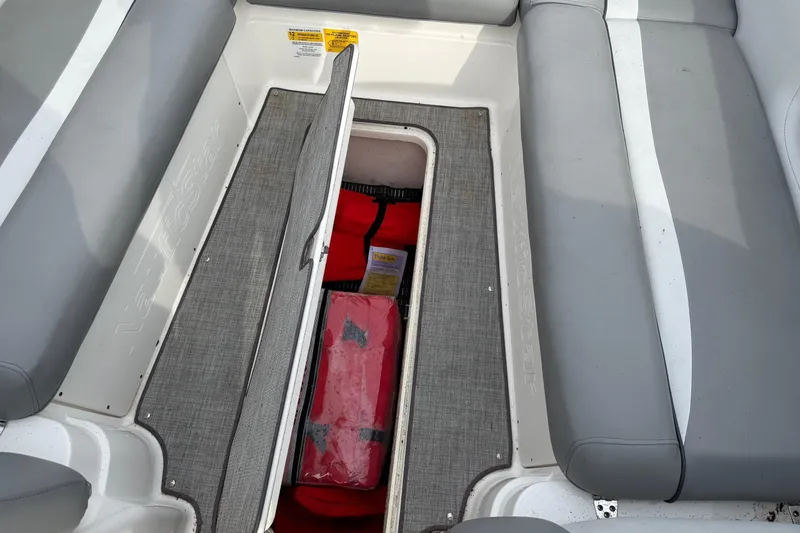 Slide: The Image of 2022 NauticStar 243 DC boat interior storage compartment with safety equipment. - 13