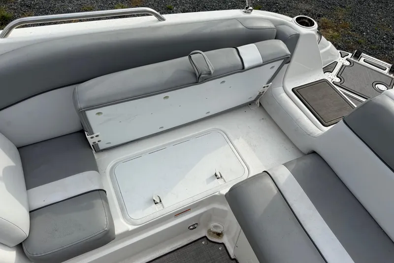 Slide: The Image of 2022 NauticStar 243 DC boat interior with gray seating and storage compartments. - 7