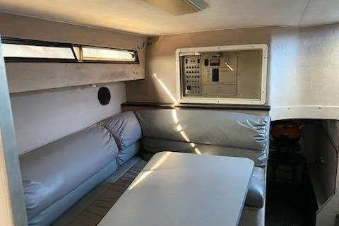 Slide: The Image of 1988 Trojan 8.6 Meter Mid-Cabin interior with seating and control panel. - 6