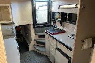 Slide: The Image of 1988 Trojan 8.6 Meter Mid-Cabin interior with kitchenette and seating area. - 8
