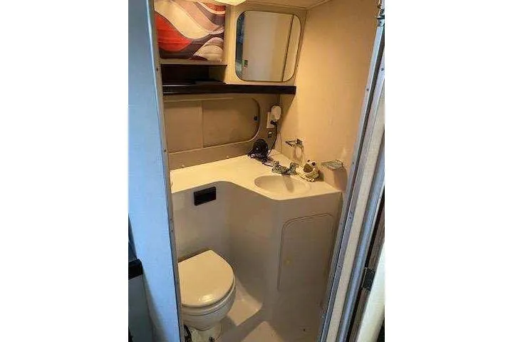 Slide: The Image of 1988 Trojan 8.6 Meter Mid-Cabin boat bathroom with sink, toilet, and mirror. - 9