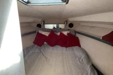 Slide: The Image of 1988 Trojan 8.6 Meter Mid-Cabin interior with bed and red pillows. - 10