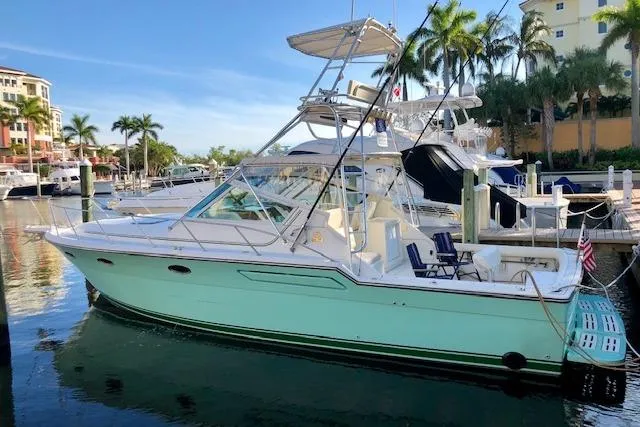 Slide: The Image of 1992 Tiara Yachts 3600 Open docked in a sunny marina with palm trees. - 1