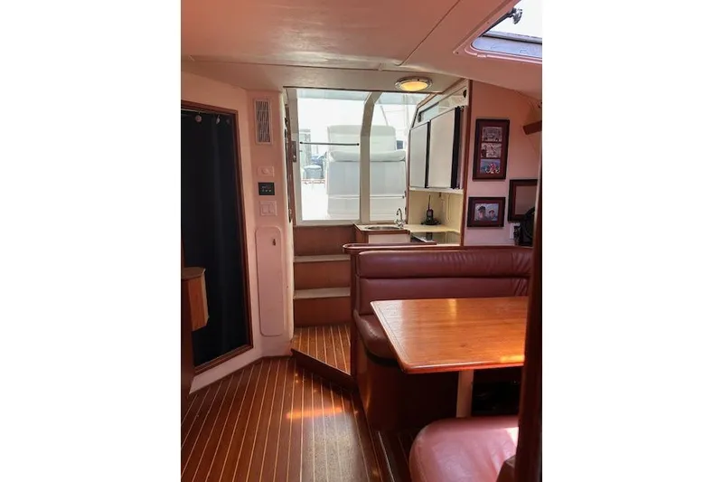 Slide: The Image of Interior of 1992 Tiara Yachts 3600 Open, featuring dining area and kitchenette. - 15