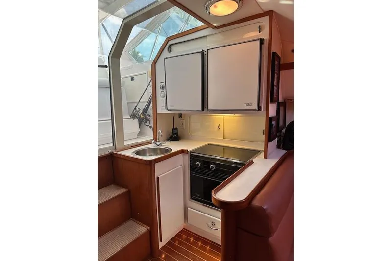 Slide: The Image of 1992 Tiara Yachts 3600 Open galley with stove, sink, and cabinetry. - 16