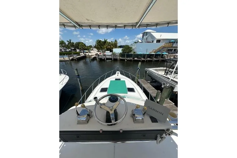 Slide: The Image of 1992 Tiara Yachts 3600 Open at dock, helm view, sunny day, waterfront setting. - 20