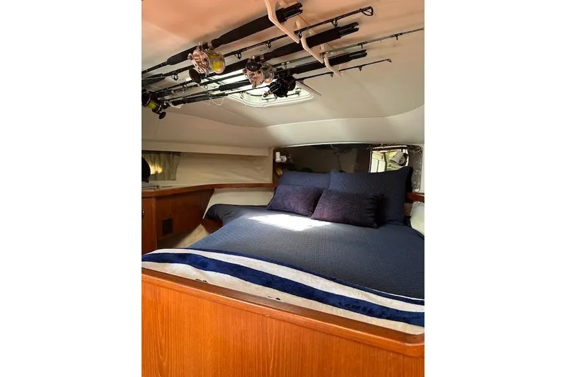 Slide: The Image of Cozy cabin interior of 1992 Tiara Yachts 3600 Open with fishing rods overhead. - 22