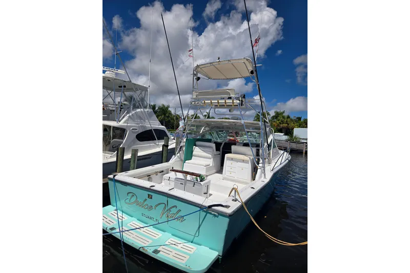 Slide: The Image of 1992 Tiara Yachts 3600 Open docked, featuring a spacious deck and clear skies. - 4