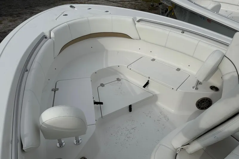 Slide: The Image of 2015 Sportsman Heritage 231 Center Console boat interior with white seating and storage compartments. - 13