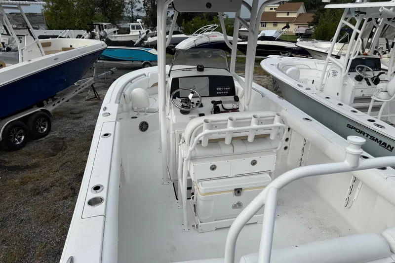 Slide: The Image of 2015 Sportsman Heritage 231 Center Console boat, white interior, parked among other boats. - 6