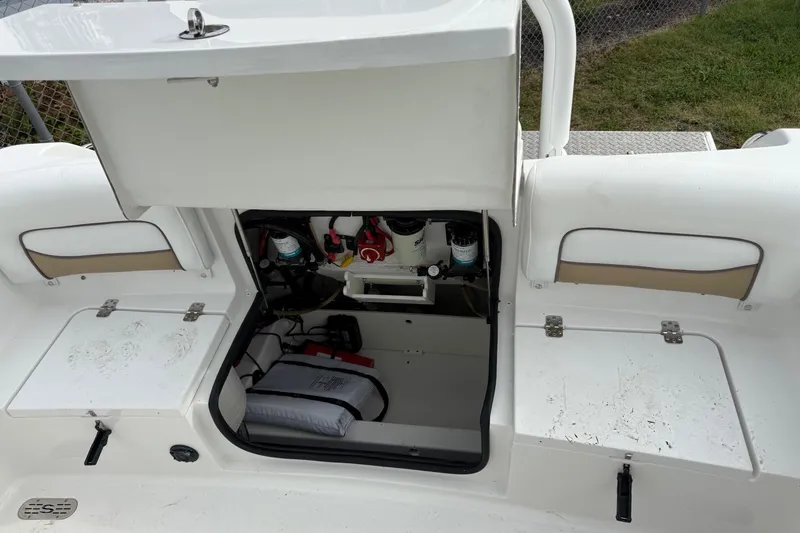Slide: The Image of Open storage compartment on 2015 Sportsman Heritage 231 Center Console boat, showing interior equipment. - 8