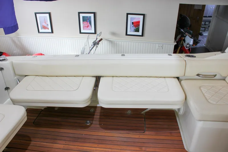 Slide: The Image of 2018 Chris-Craft Calypso 30 interior with white seating and wooden flooring. - 29